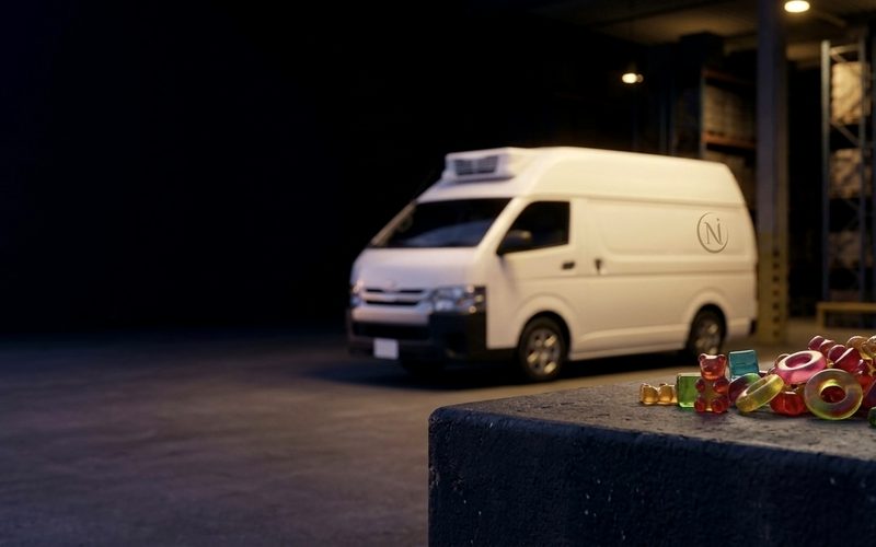 A refrigerated NUMU Foods van parked inside the central warehouse between racking